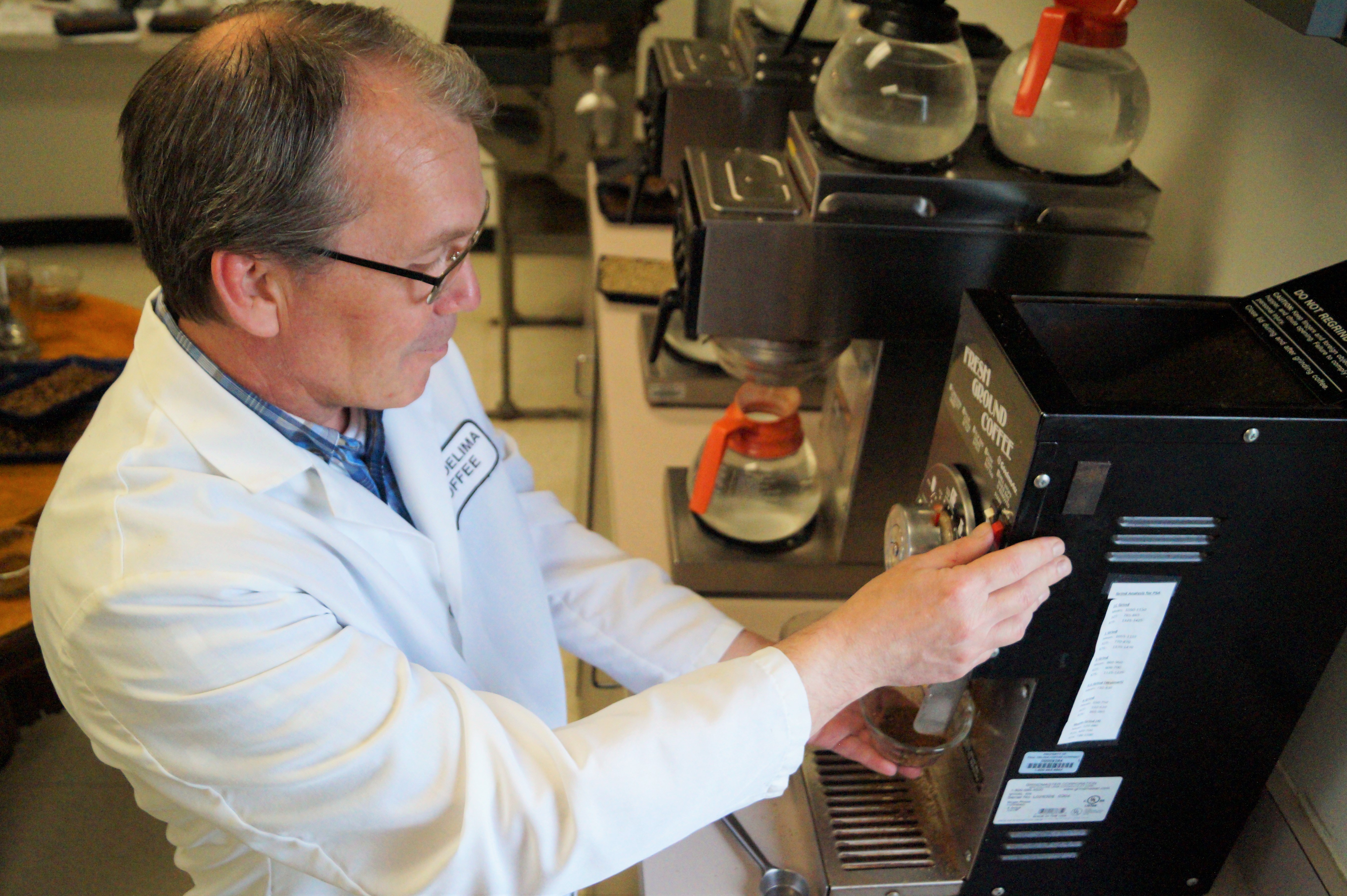 Glenn grinds coffee beans in preparation for tasting during the cupping process.
