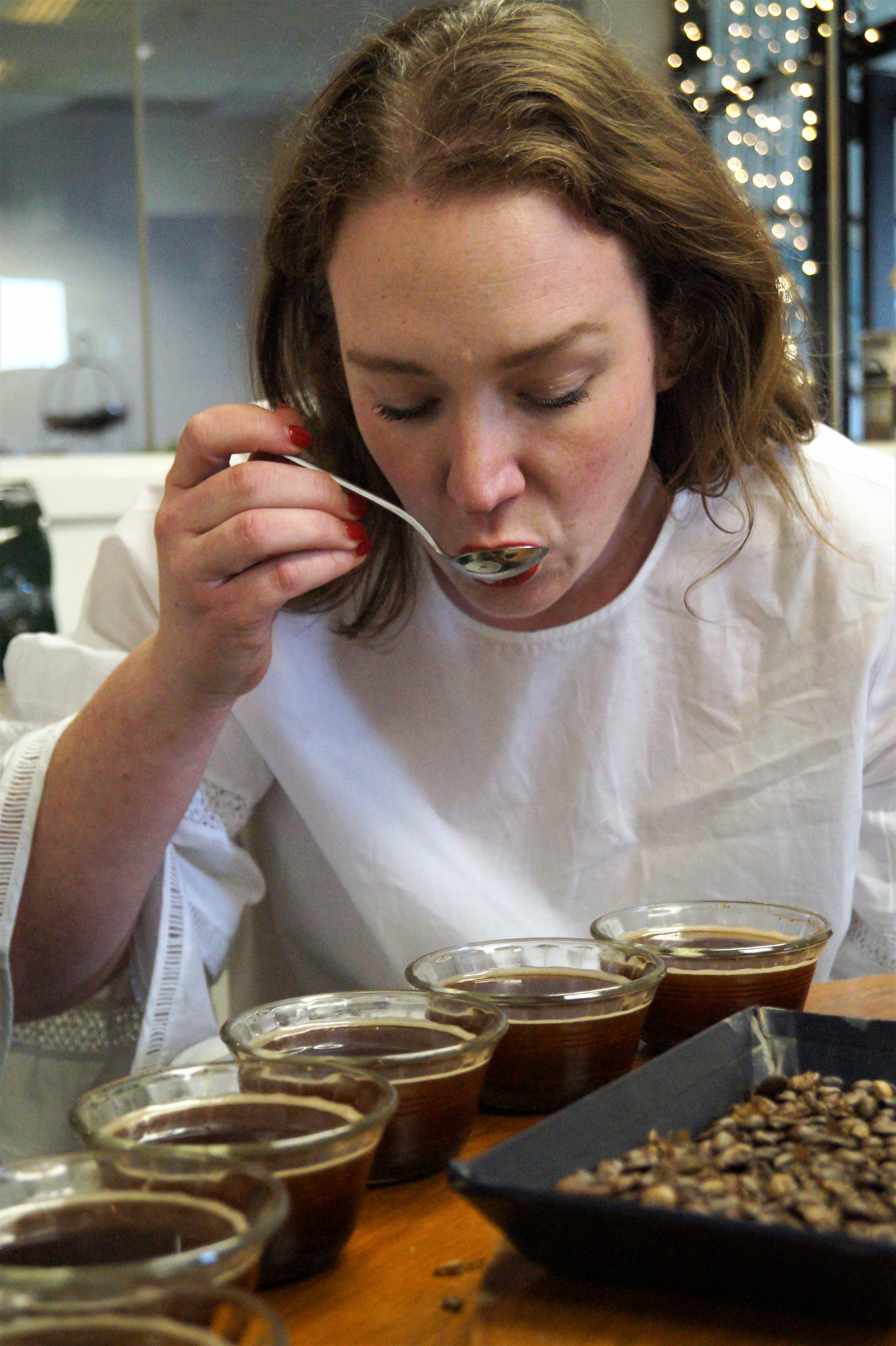 Kate cupping the coffee samples that Glen has already tasted. Multiple cuppers will evaluate each sample.