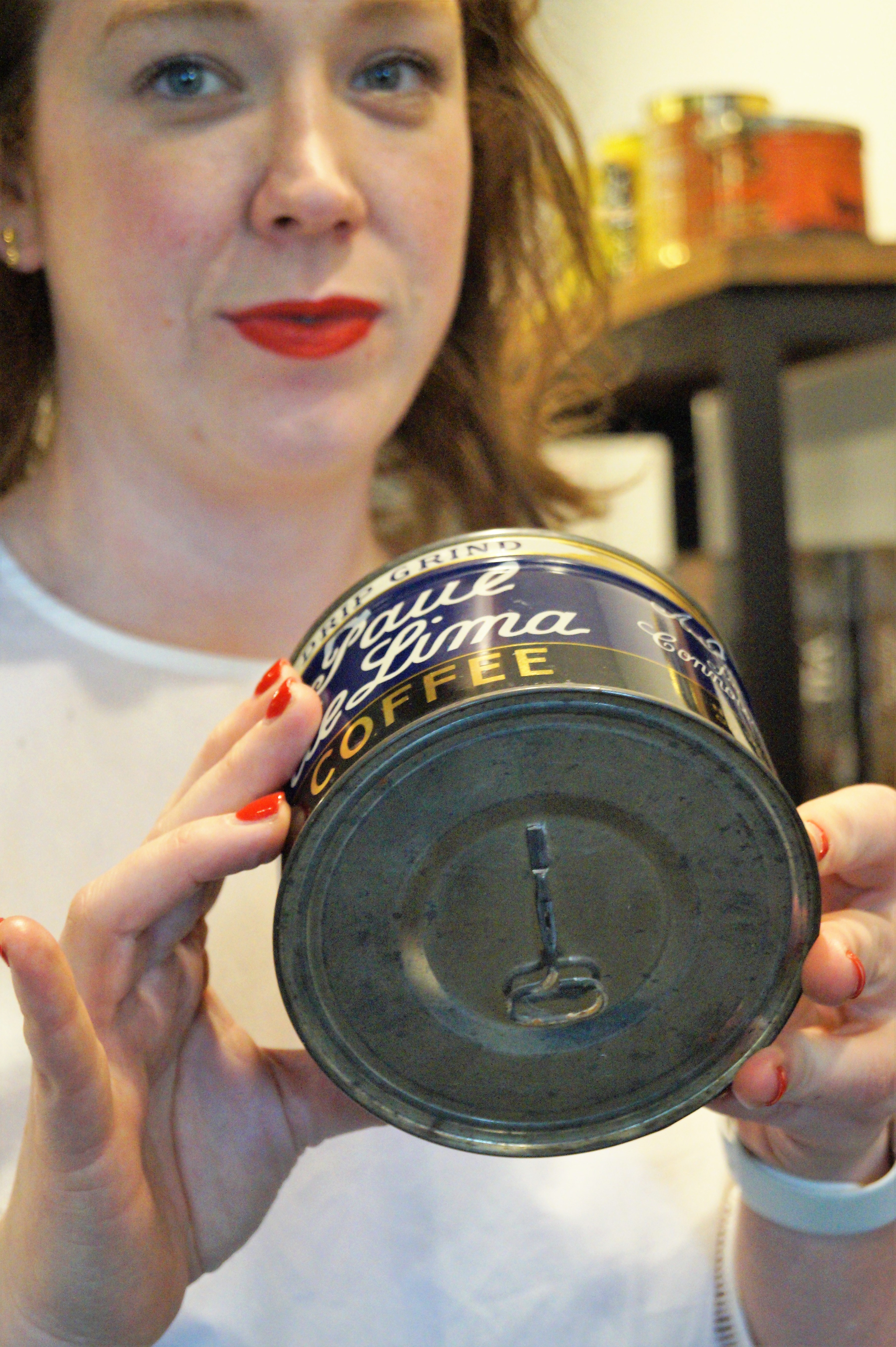 Kate holds the favorite antique coffee can from the collection on display. The can still has its key attached and is full of coffee.