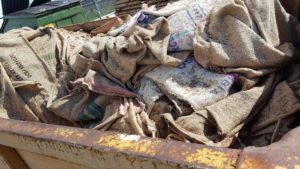 Dumpster of burlap sacks that held coffee beans in shipment and are free for the taking at Paul deLima roasting facility.